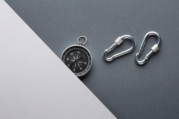 Carabiners with compass on gray background. Tourism, outdoor activities
