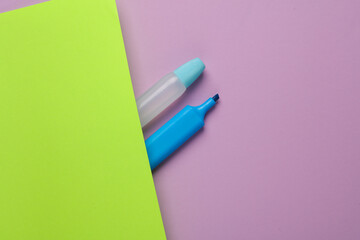 Accessories for creativity. Glue with a marker on a green-purple background