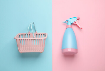 Spray bottle in shopping basket on blue pink background