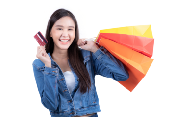 Standing sweet woman in denim shirt holding shopping bag and credit card in hand. Isolated on white background
