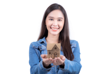 Standing sweet woman in denim shirt offering miniature house in hand. Isolated on white background