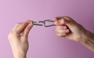 Fototapeta premium Metal carbines in a female hands on a purple background