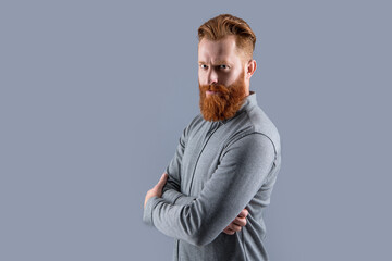 Irish man half turn keeping arms crossed. Confident man with beard and mustache. Bearded man