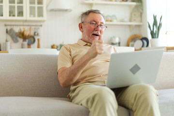 Excited middle aged senior man euphoric winner. Older mature grandfather looking at laptop reading great news getting good result winning online bid feeling amazed. Winning gesture