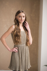 Fototapeta premium Fashion young woman wearing grey clothes posing on grey background