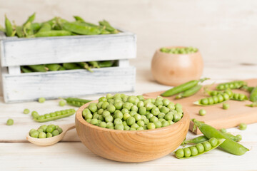 Composition with fresh green peas on wooden table