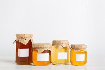 Jars with honey on wooden table. Mock up design