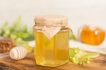 Linden honey with leaves and flowers on wooden table