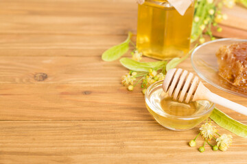 Linden honey with leaves and flowers on wooden table