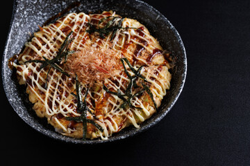 Okonomiyaki traditional japanese food isolated in black background