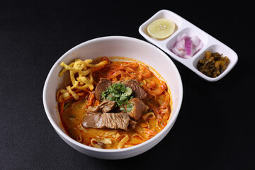 Khao Soi Thai Curry soup isolated in black background