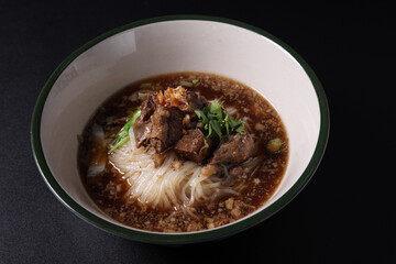 Braised pork noodles Thai street food isolated in black background