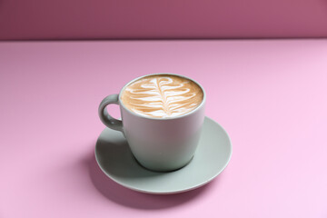 hot cappuccino with latte art isolated in pink background