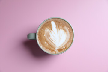 hot cappuccino with latte art isolated in pink background