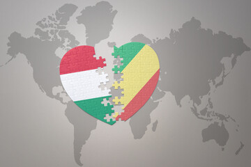 puzzle heart with the national flag of republic of the congo and hungary on a world map background.Concept.