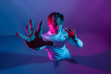 robot-like man stand in studio with futuristic feel, embodying the concept of technology while strike confident pose with hands up, demonstrating progress and advancement of artificial intelligence