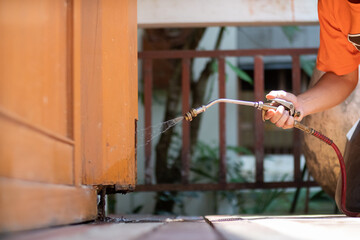 man chose to use exterminate chemicals Termites that are not toxic to humans are mixed with water in a tank for spraying Exterminate termites allow young men to spray termites themselves by himself