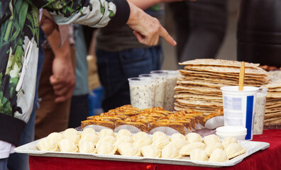 A visitor to the street market choosing a snack from a stand selling Azerbaijani specialities at...
