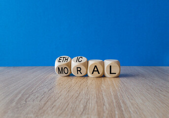 Ethical or moral symbol. Businessman turns wooden cubes and changes the word 'moral' to 'ethical'...