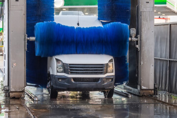 Automatic wash blue brush rotate in action, white mini vancar comes out ready clean
