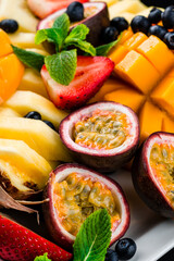Vitamin fruit and berry plate with mango, pineapple, passion fruit, strawberry, blueberry and mint.