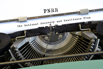 words 'PNRR The National Recovery and Resilience Plan' typed on vintage typewriter. The National Recovery and Resilience Plan is part of the Next Generation programme.