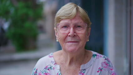 Close-up face of a senior woman looking at camera smiling. Portrait of an elderly Caucasian female person in 80s, old age wisdom concept