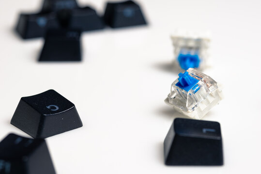 Keycaps and Keyswitch for Mechanical Keyboards Scattered on White Background