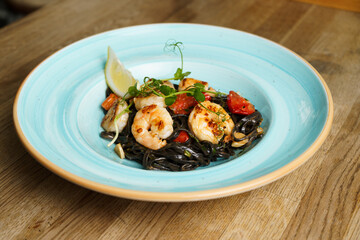 Squid ink pasta with shrimp, tomato and lemon