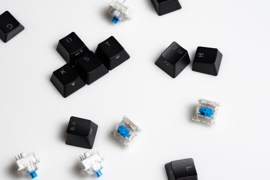 Keycaps and Keyswitch for Mechanical Keyboards Scattered on White Background