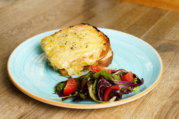 Classic french toast with cheese and ham, vegetables and honey-balsam dressing