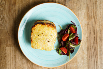 Top down view of Classic french toast with cheese and ham, vegetables and honey-balsam dressing