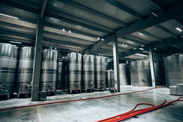 Huge warehouse for wine storing with giant stainless steel tanks. Industrial production of alcohol...