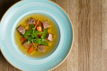 Top Down View of Beef Soup in a Plate on a wooden table