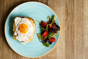 Top Down view of Classic french toast with cheese and ham, fried eggs, vegetables and honey-balsam dressing