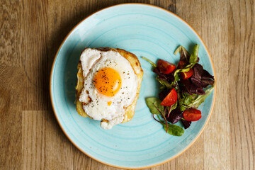 Top Down view of Classic french toast with cheese and ham, fried eggs, vegetables and honey-balsam dressing