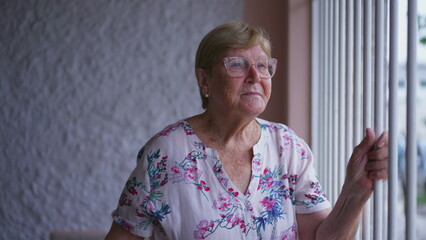 Obraz premium Senior Woman Looking at Neighborhood Behind Gated Home, Elderly Person in 80s Engaging in Neighborhood Observation