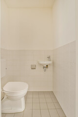 Fototapeta na wymiar a white toilet in a bathroom with tile flooring and wall mounted fixtures on the side of the toilet bowl