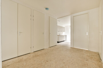 an empty room with white closets and doors on either side, looking towards the entrance to the living room