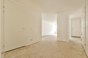 an empty room with white walls and wood flooring in the middle part of the room there is a door leading to another room