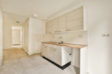 an unfinished kitchen with white cabinets and wood counter tops on the floor in a room that is being used for storage
