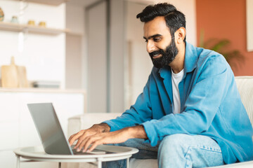 Middle eastern guy freelancer working online with laptop from home