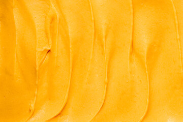 Waves of mango or apricot sweet ganache or cream for covering and decorating cakes, macarons and desserts