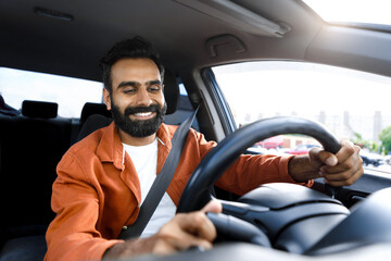 Confident indian man driving his new auto sitting in automobile