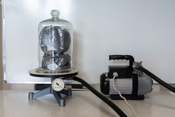 Inflatable doll under a bell jar that is vacuum sucked by a pump. Demonstration experiment in...