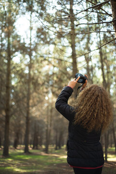 woman taking a picture of a forest pine