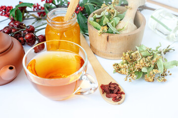 herbal medicine composition linden herb tea, honey, rose hips and goji berries on a white background