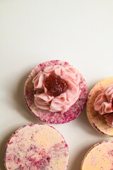 Close up view of set of colorful fresh halves of macarons decorated with sweet berry ganache and jam