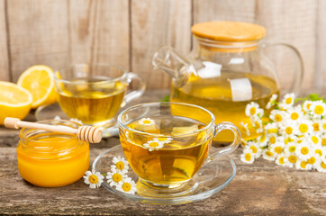 Chamomile tea in a glass cup on a brown textured background. Natural hour with chamomile flowers. Herbal tea. Immunity tea.Natural healer concept. Healthy detox drink.Close up. Place for text.