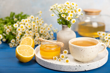 Chamomile tea in a white cup on a blue textured background. Natural hour with chamomile flowers. Herbal tea. Immunity tea.Natural healer concept. Healthy detox drink.Close up. Place for text.